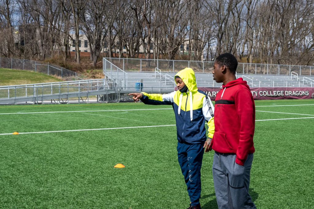 Jahlil with a mentee on a football field