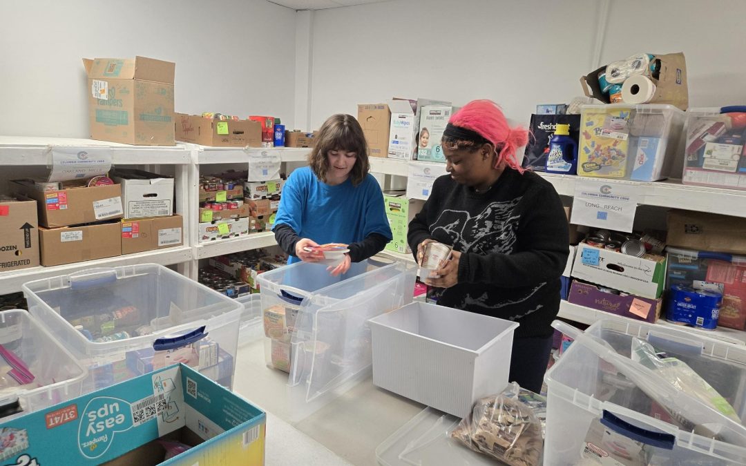 Jocelyn and Sophia restock the shelved at the CCC food pantry