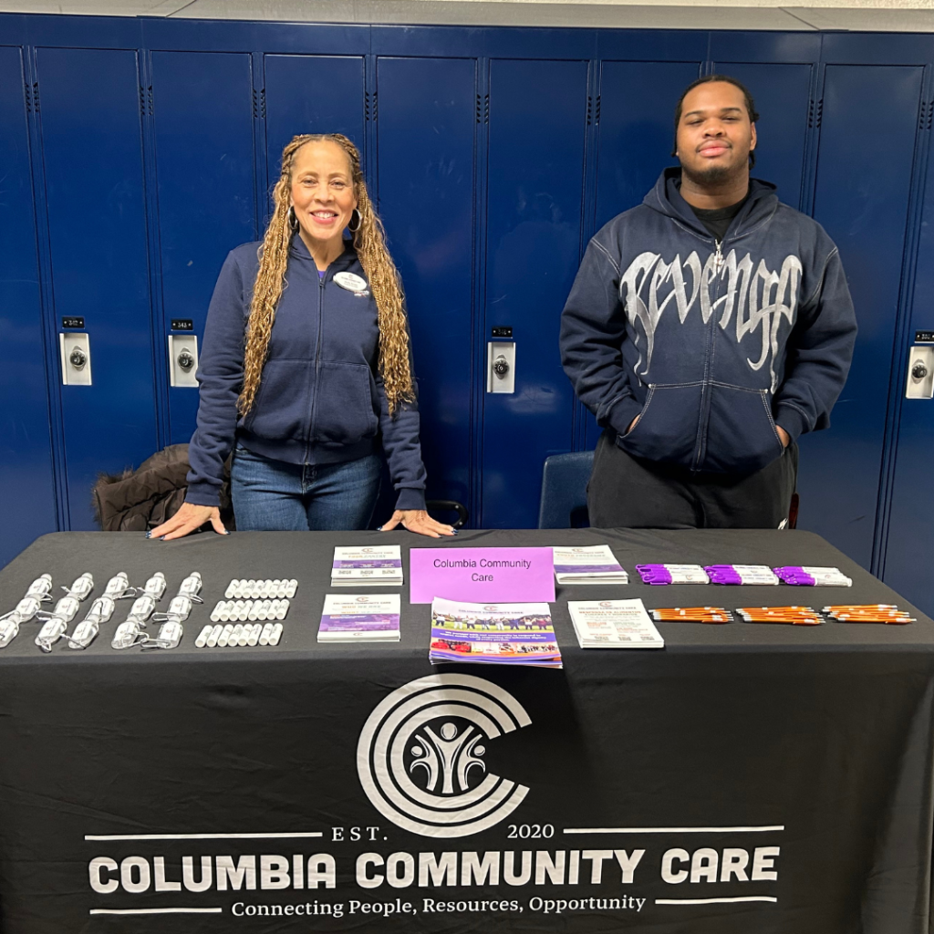 Shelly Brown stands behind a table with CCC information.