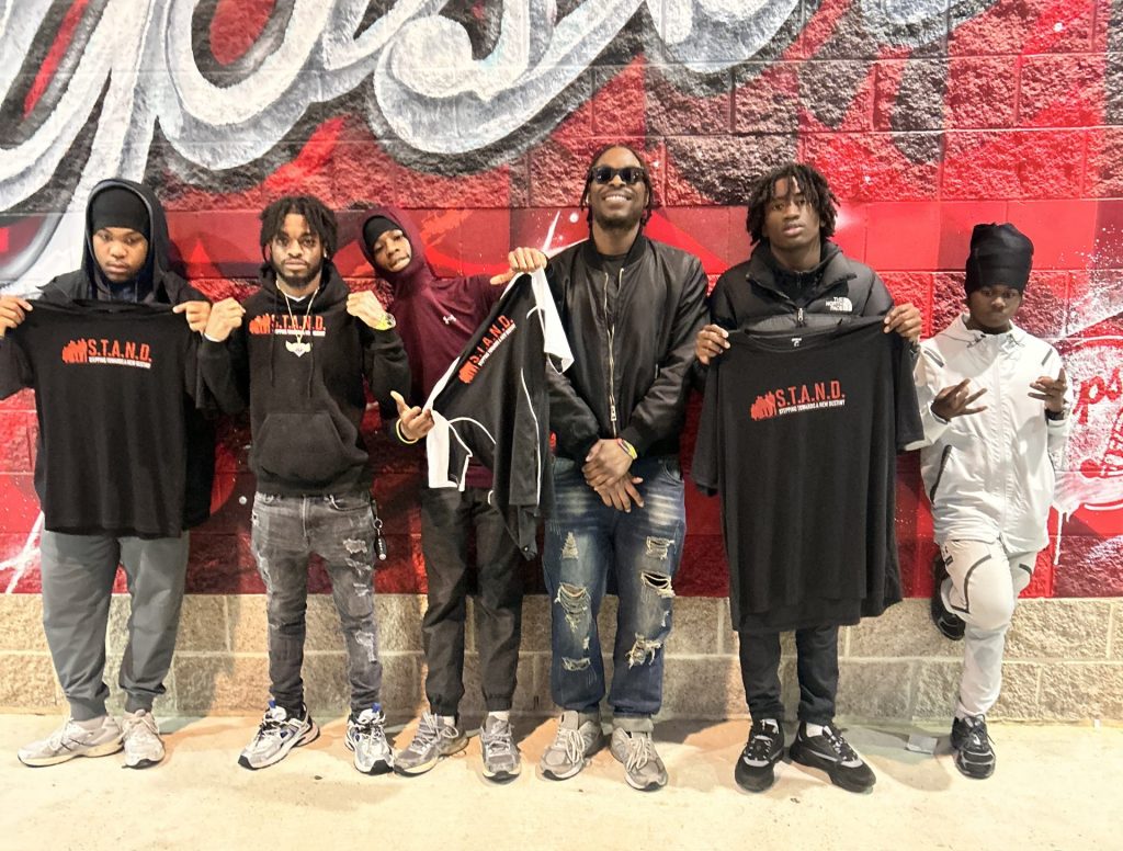 Malcolm Davis stands with a group of young boys in the STAND program